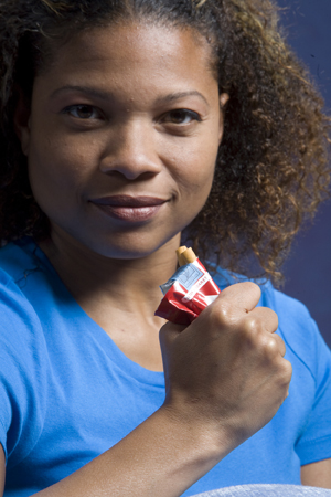 Woman crushing pack of cigarettes in hand.