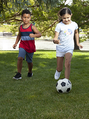 Boy and girl outside, running.