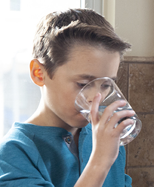 Niño bebiendo agua.